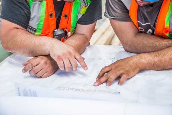 constructionandengineering Construction workers looking at blueprints
